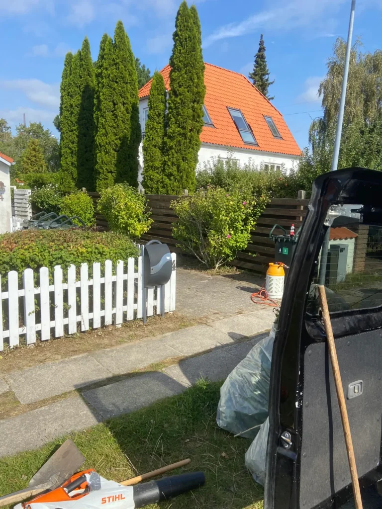 Forhave med hvidt stakit og nyklippet hæk