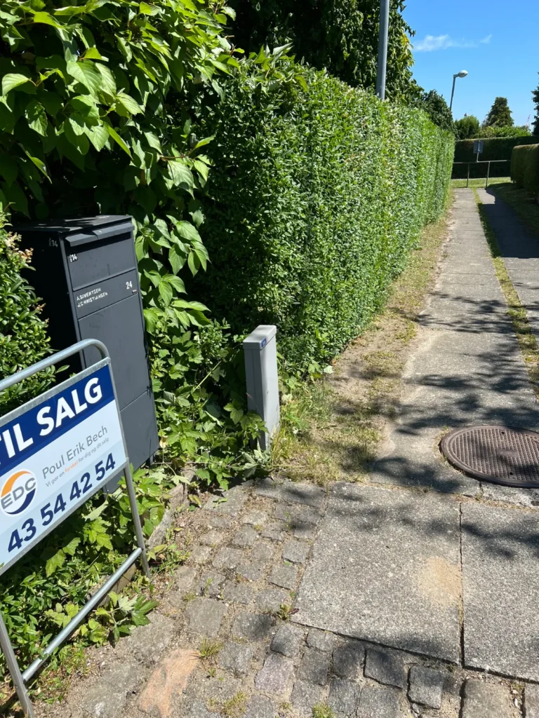 Klippet hæk langs fortov ved villa