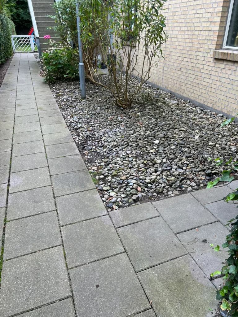 Flisegang og stenbed ved hus